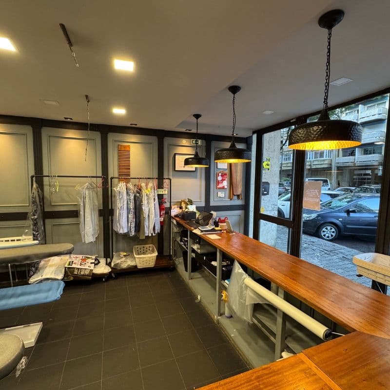 Vista interior da loja com balcão de madeira e luminárias pendentes